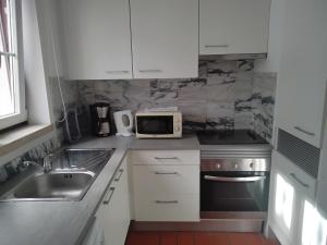 a small kitchen with a sink and a microwave at Great duplex in historical center in Lisbon