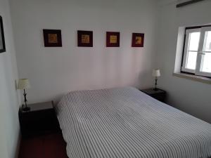 - une chambre avec un lit et trois photos sur le mur dans l'établissement Great duplex in historical center, à Lisbonne