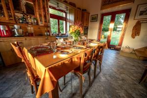 einen Esstisch in einer Küche mit einem gelben Tischtuch in der Unterkunft Csárdás Salaš in Dobrovnik