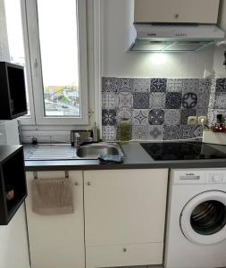 Il comprend une cuisine équipée d'un évier et d'un lave-linge. dans l'établissement appartement, à Vitry-sur-Seine