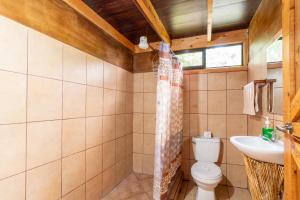 a bathroom with a toilet and a sink at Cabaña El Ciprés: Vistas increíbles y Mirador in Turrialba