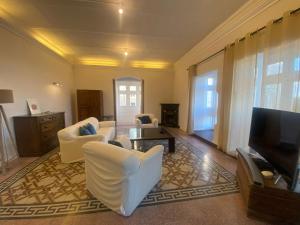 Il comprend un salon doté d'un mobilier blanc et d'une télévision à écran plat. dans l'établissement SeaView Valletta Apartment, à La Valette