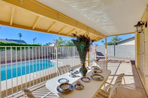 uma mesa com um vaso ao lado de uma piscina em Glendale Oasis with Private Pool, Patio and Fireplace! em Phoenix