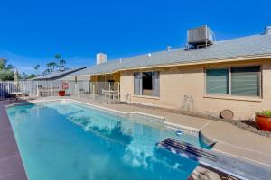 a swimming pool in front of a house at Glendale Oasis with Private Pool, Patio and Fireplace! in Phoenix