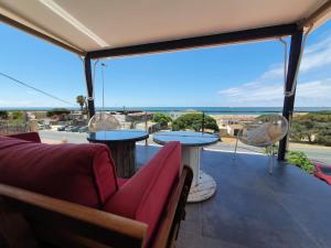 Un balcón con mesas y sillas y vistas al océano. en Mazagón relaj, en Palos de la Frontera
