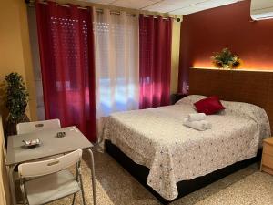a bedroom with a bed and a table with a laptop at Hostal Happystay in Valencia