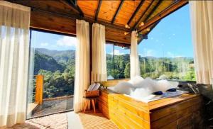une chambre avec une grande fenêtre avec vue sur les montagnes dans l'établissement Chalé Canto da Montanha, à Annitapolis 27 autres photos