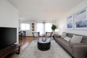 ein Wohnzimmer mit einem Sofa und einem Flachbild-TV in der Unterkunft Newly Renovated 2BR with Parking and Near NLRHC in Fort McMurray