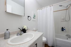 a white bathroom with a sink and a shower at Newly Renovated 2BR with Parking and Near NLRHC in Fort McMurray