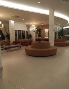 a lobby with a couch and tables and chairs at Enjoy Thermas de São Pedro in São Pedro