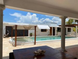 a villa with a swimming pool and a house at Casa familiar, alberca privada, pasos de la playa in Progreso