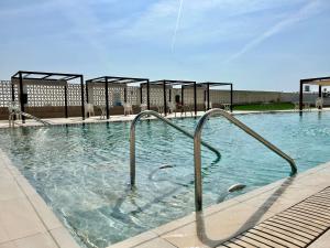 a swimming pool with metal hand rails in the water at Mareny de Barraquetes in Mareny Blau