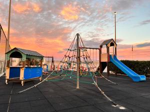 een speeltuin met een glijbaan en een speelstructuur bij Mareny de Barraquetes in Mareny Blau