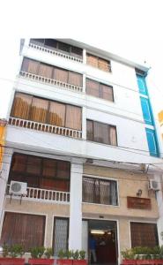 a tall white building withwindows and a basketball hoop at Hotel Roca & Mar in Santa Marta