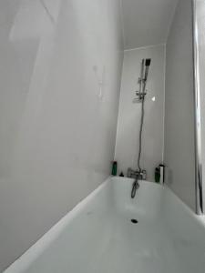 ロンドンにあるRelaxing&Cozy Roomのバスルーム(白いバスタブ、シャワー付)