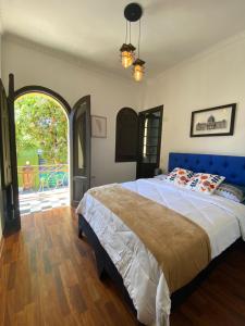 a bedroom with a large bed with a blue head board at Hostal El Raco in Santiago