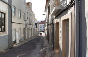 un callejón vacío con gente caminando por la calle en Casa da Tia Matilde, en Sesimbra