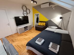 a bedroom with a blue bed and a flat screen tv at SND Aparts in Novi Sad +18 photos