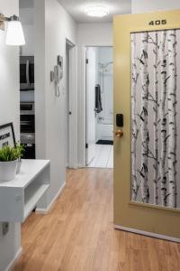 a hallway with a door with a tree mural at Downtown 1BR Top Floor with View Free Parking in Fort McMurray