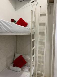 2 literas con almohadas rojas en una habitación en Hostal Marbella 47, en Cartagena de Indias