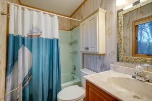 a bathroom with a toilet sink and a shower curtain at Outer Banks Retreat - Walk to Beach! in Southern Shores +19 photos