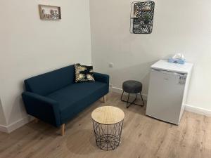 a living room with a blue couch and a table at Appartement le petit Royal in Cormelles