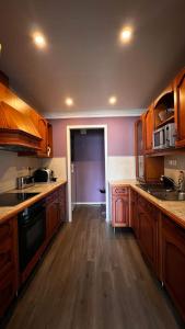 a kitchen with wooden cabinets and wooden floors at Face Of North in Gratangen
