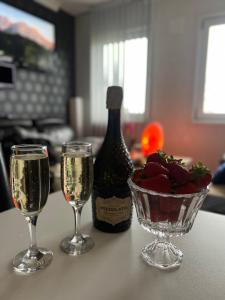 two glasses of champagne and a bowl of strawberries and a bottle of wine at Face Of North in Gratangen