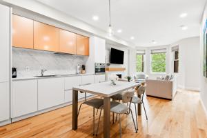 a kitchen with white cabinets and a table and chairs at 4bdr/4bth penthouse with roof terrace in Washington, D.C.