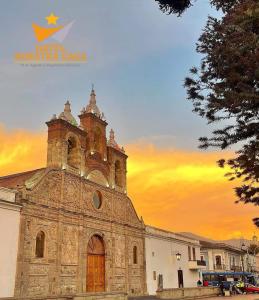 an old church with a sunset in the background at Hotel Nuestra Casa in Riobamba