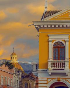 ein gelbes Gebäude mit einer Kuppel darüber in der Unterkunft Hotel Nuestra Casa in Riobamba
