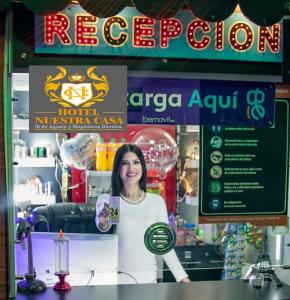 Una donna in piedi dietro un bancone in un negozio di Hotel Nuestra Casa a Riobamba