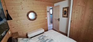 a small bedroom with a bed and a mirror at Bas de châlet Noémaé in Eyne