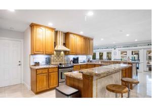 cocina grande con armarios de madera y encimera en Casa de Cox, Home w/heated pool, en Southwest Ranches