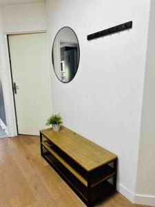 Zimmer mit einem Tisch und einem Spiegel an der Wand in der Unterkunft Appartement lumineux et spacieux proche gare in Villeurbanne