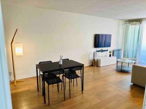 einen schwarzen Tisch und Stühle im Wohnzimmer in der Unterkunft Appartement lumineux et spacieux proche gare in Villeurbanne