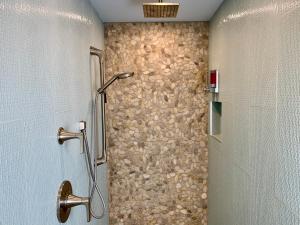 a shower in a bathroom with a stone wall at Vista Grande Resort - A Gay Men's Resort in Palm Springs