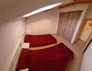 Habitación pequeña con 2 camas y sofá rojo. en Résidence Saint Florent Oletta, en Saint-Florent