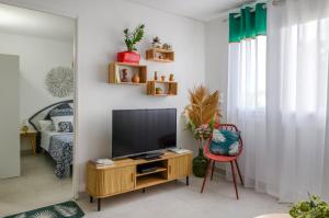 a living room with a television and a chair at Shoumy in Les Trois-Îlets