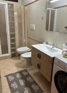 y baño con lavabo, aseo y espejo. en Demetra Apartment Sperlonga en Sperlonga