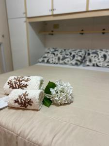 Una cama con toallas y flores encima. en Demetra Apartment Sperlonga en Sperlonga