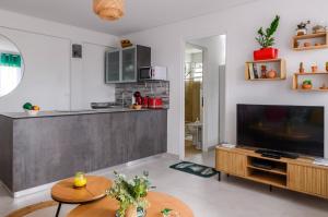 a living room with a television and a table at Shoumy in Les Trois-Îlets