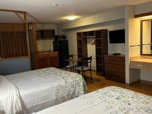 een kleine hotelkamer met 2 bedden en een keuken bij HomeTowne Studios by Red Roof Amarillo West in Amarillo