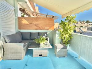um pátio com um sofá e uma mesa na varanda em Luxury Apt 115m2 em Atenas