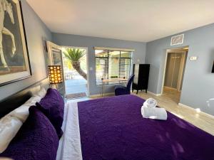 a bedroom with a purple bed with a purple blanket at Vista Grande Resort - A Gay Men's Resort in Palm Springs