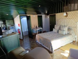 a bedroom with a bed and a kitchen with a sink at Los Balcones de Galaz in Chinchón