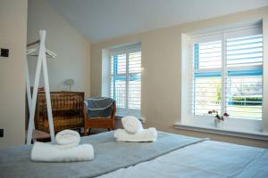 a bedroom with two towels on a bed with a window at The Stables, converted barn outside York in York