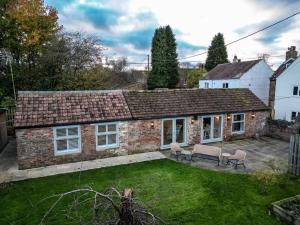 an old brick house with chairs and a yard at The Stables, converted barn outside York in York