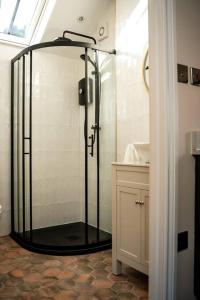 a shower with a glass door in a bathroom at The Stables, converted barn outside York in York