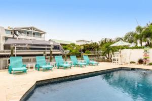 - un groupe de chaises bleues assises à côté d'une piscine dans l'établissement Mermaid Manor - Anna Maria, FL, à Anna Maria